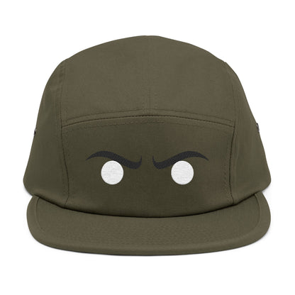 Green cap with cartoonish eyes on a white background. Black curved eyebrow shapes paired with intense white circular eyes. TEEZOCA