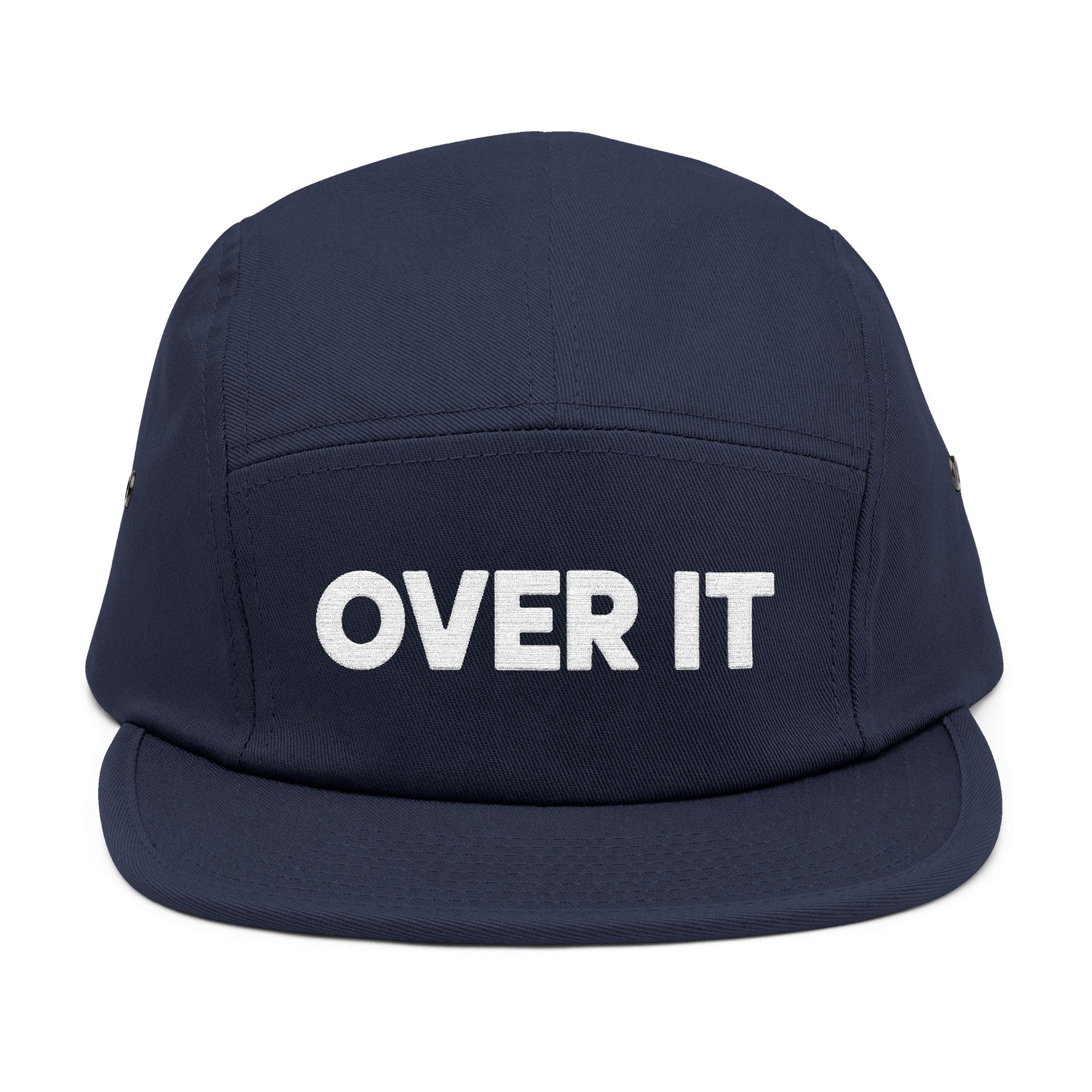 Navy blue cap with 'OVER IT' text on a white background. OVER IT embroidered text design displayed on clean white typography. TEEZOCA