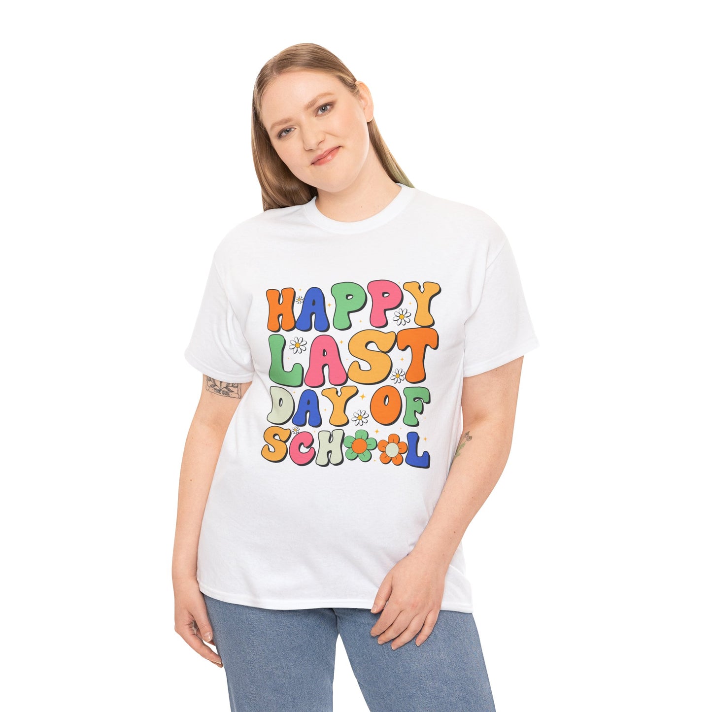 “Female model wearing Teezoca Happy Last Day of School t-shirt, retro rainbow letters and daisies, white unisex tee, front.”


