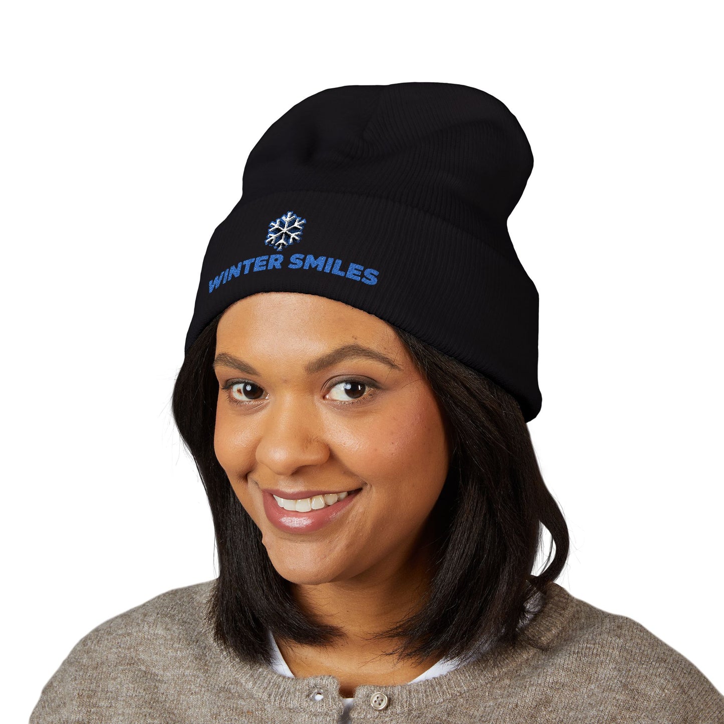 Person wearing a black beanie with 'Winter Smiles' text on a white background. Cuffed winter beanie featuring bold “Winter Smiles” lettering