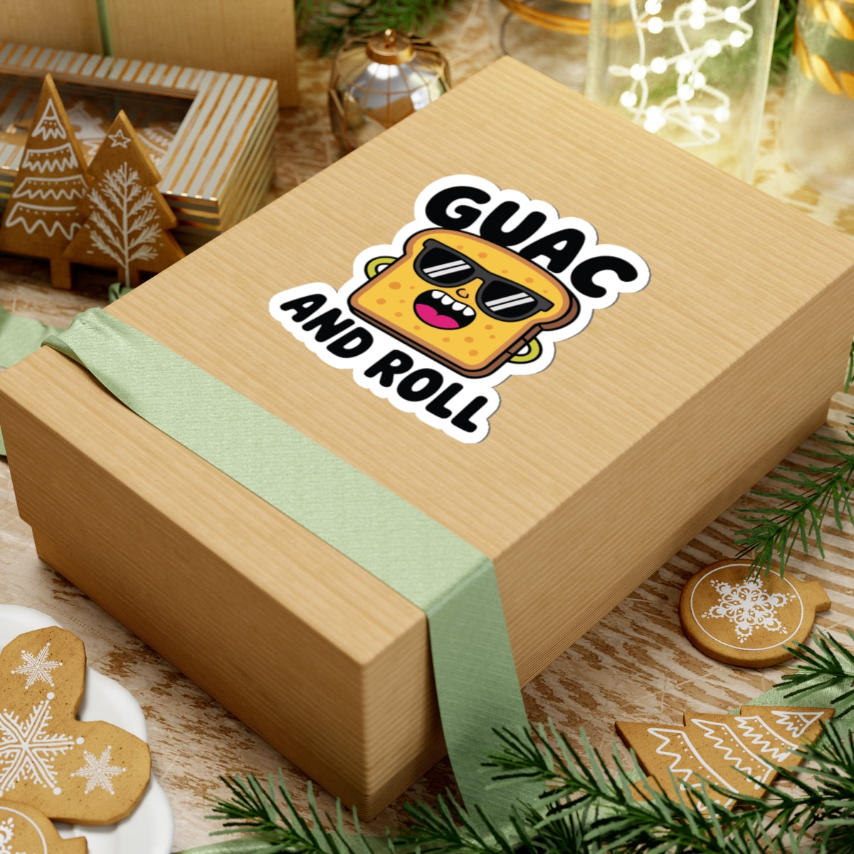 Wooden gift box with a 'Guac and Roll' sticker on a festive background with cookies and lights. TEEZOCA