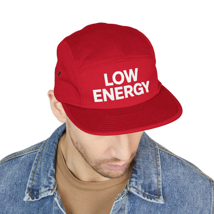 Red cap with 'LOW ENERGY' text worn by a person on a white background. Low Energy embroidered text on five-panel cap minimalist design. TEEZOCA