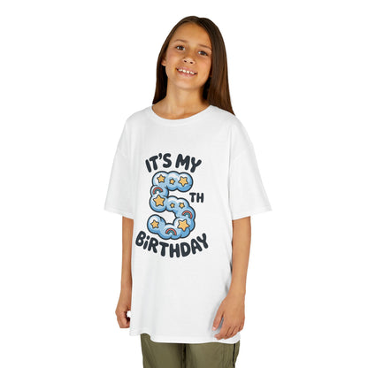 Girl wearing White kids’ t‑shirt with blue cloud number 5, yellow stars, mini rainbows, and “It’s My 5th Birthday” text, flat front view.