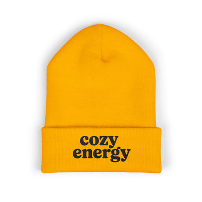 Yellow beanie with 'cozy energy' text on a white background