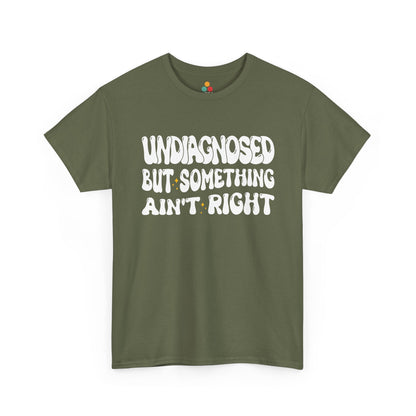 “Teezoca Undiagnosed But Something Ain’t Right shirt, groovy white text design, olive green tee, laid flat.”​

