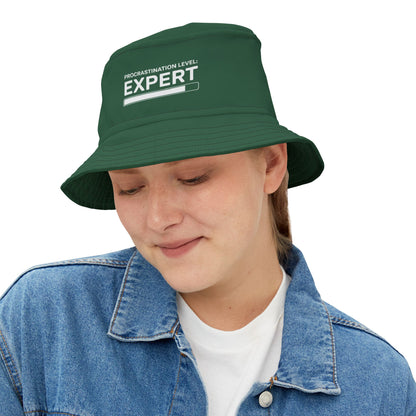 Funny sarcastic green bucket hat with 'Procrastination Level: Expert' text on a white background. TEEZOCA