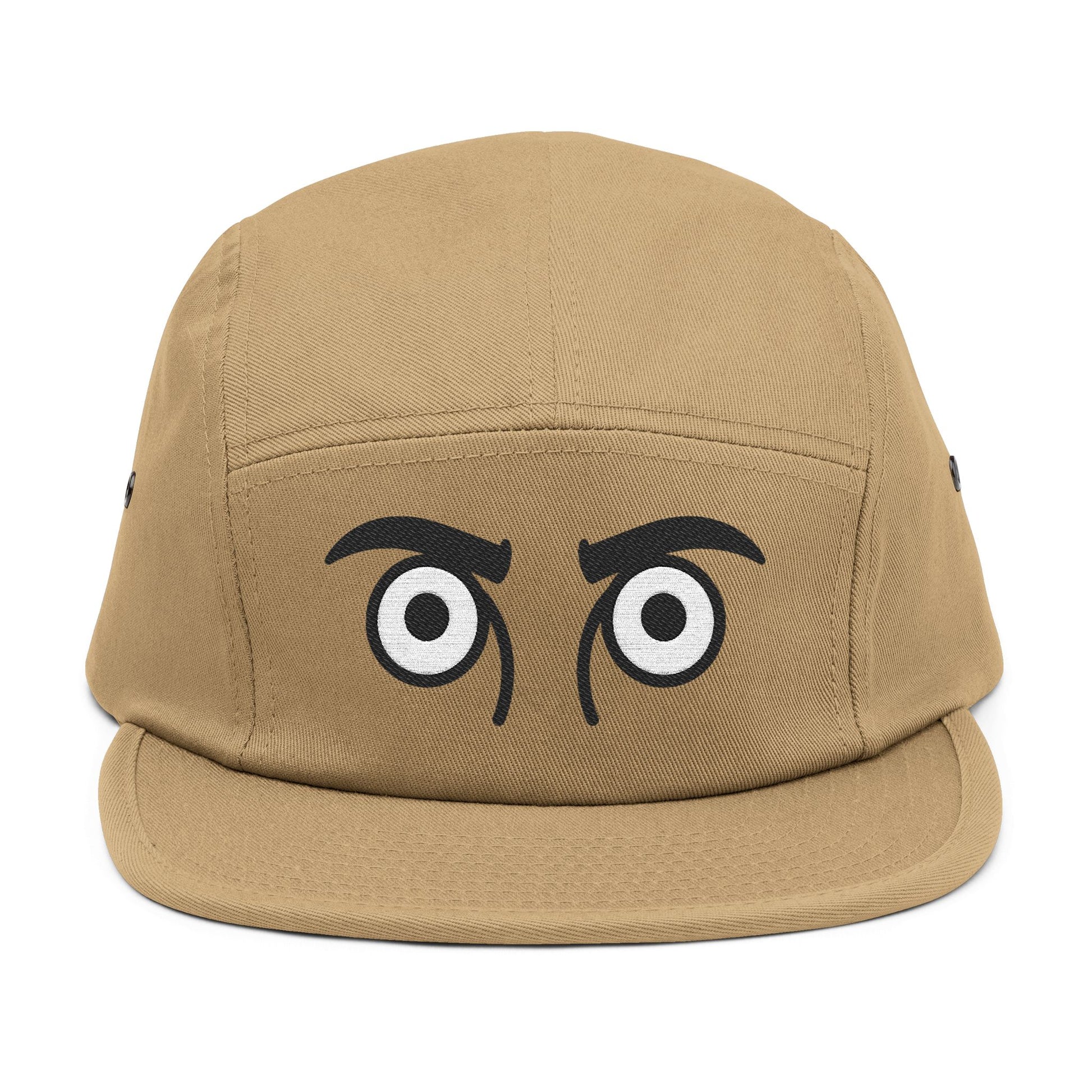 Tan cap with cartoonish eyes on a white background. TEEZOCA