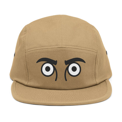 Tan cap with cartoonish eyes on a white background. TEEZOCA