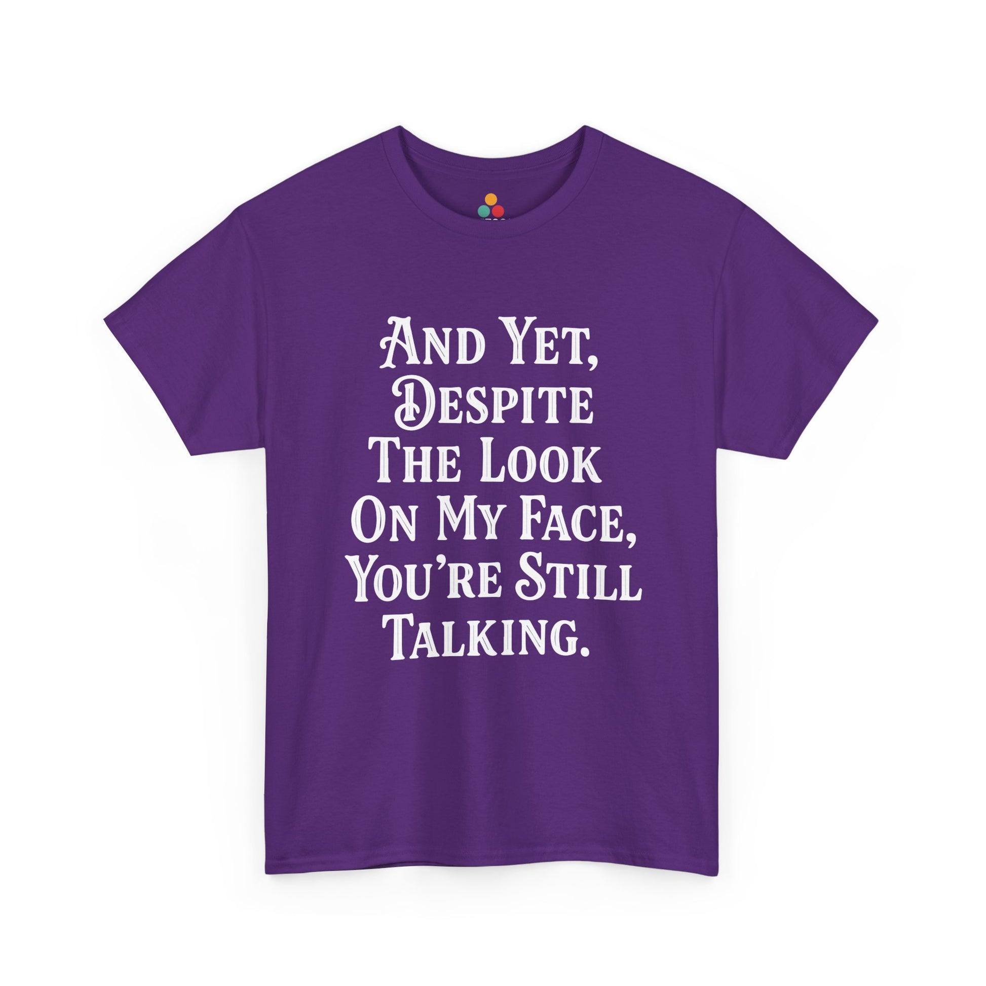 “Teezoca And Yet Despite the Look on My Face You’re Still Talking shirt, funny introvert quote design, purple tee, flat front display.”

