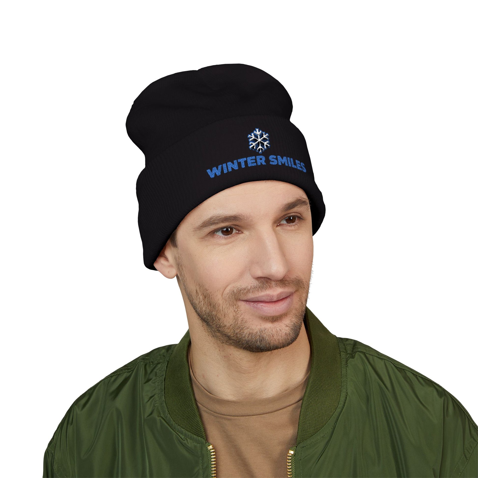 Man wearing a black beanie with 'Winter Smiles' text on a white background. Minimalist embroidered winter hat with cheerful seasonal design