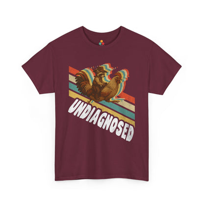 “Teezoca Undiagnosed shirt, cowboy raccoon and rainbow rooster riding graphic, maroon tee, front view.”

