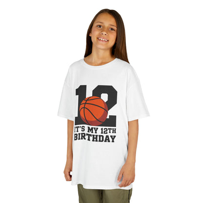 White Pink kids’ t‑shirt with big black “12” and orange basketball plus “It’s My 12th Birthday” sports graphic, flat front view.