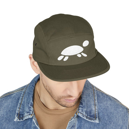 Man wearing a green cap with a white turtle design on a white background. Minimalist turtle outline embroidery design for 5-panel caps by TEEZOCA