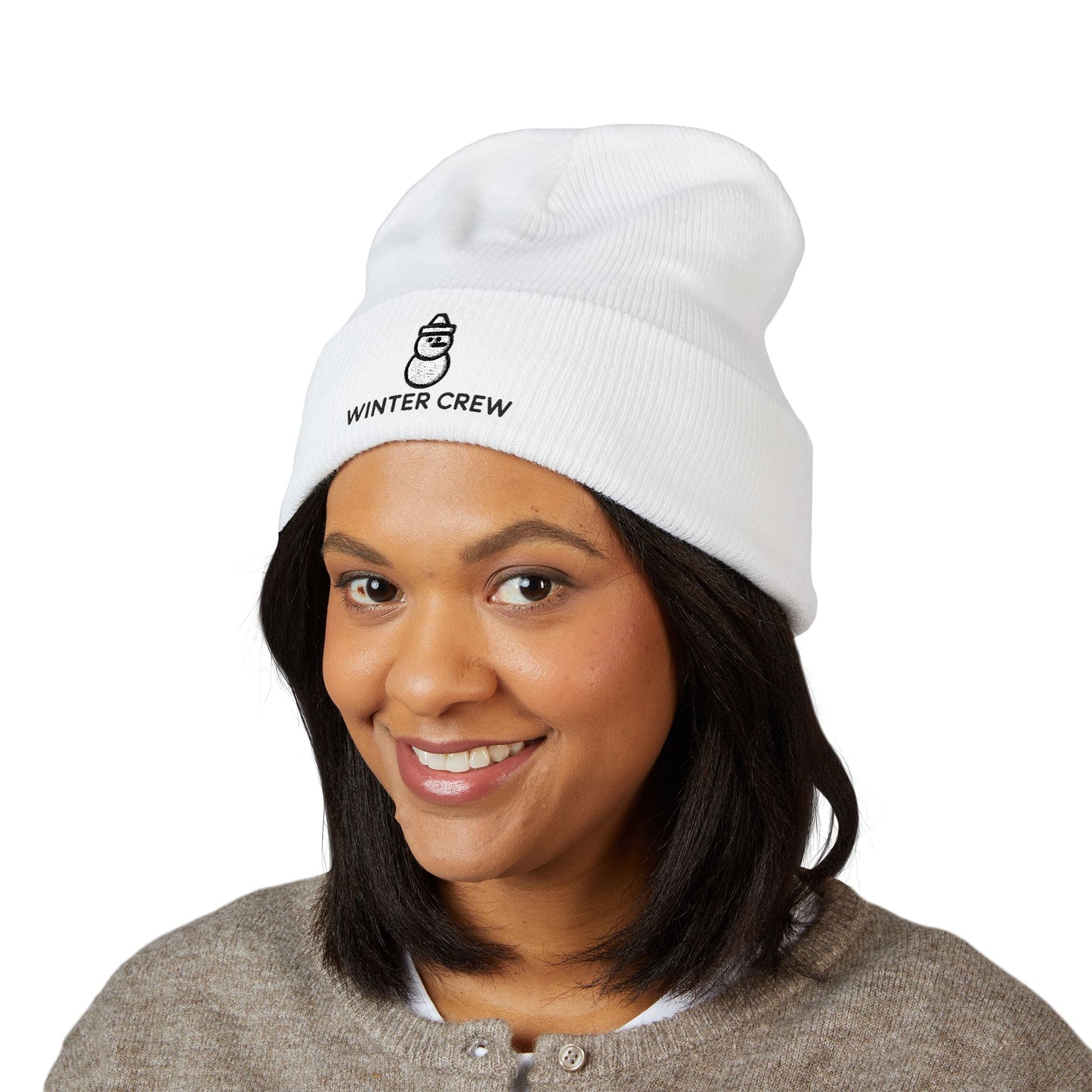 Person wearing a white beanie with 'Winter Crew' text on a white background. Soft cuffed knit hat with snowman graphic for cold-weather outfits