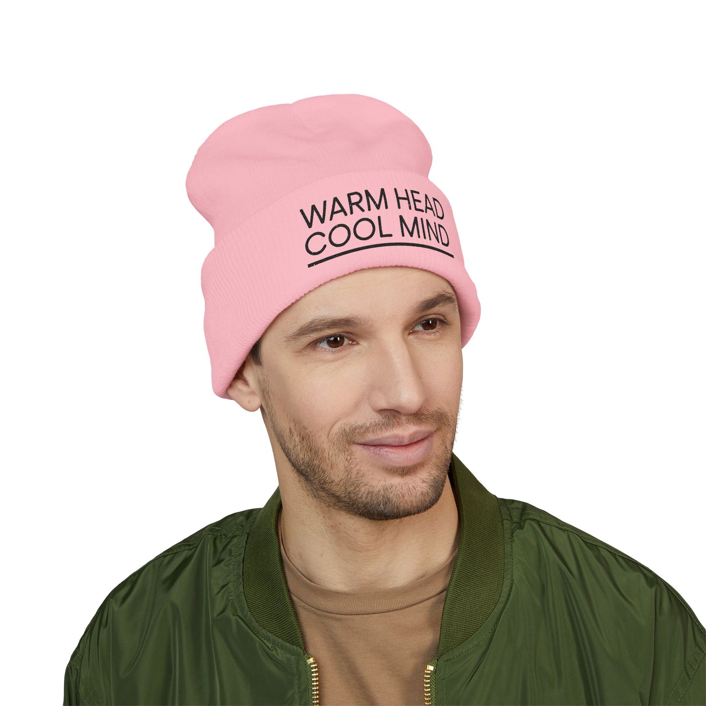 Person wearing a pink beanie with text, standing against a white background. Cuffed winter beanie with ‘Warm Head Cool Mind’ stitched on the fold