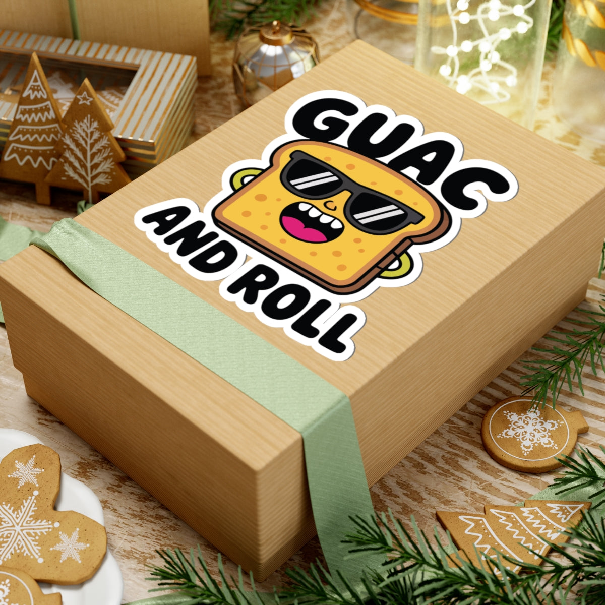 Wooden gift box with a cartoon guacamole face and 'Guac and Roll' text, surrounded by festive decor. TEEZOCA