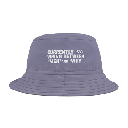 Purple bucket hat with white funny text 'Currently Vibing Between MEH and WHY' on a white background. TEEZOCA