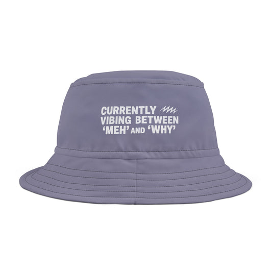 Purple bucket hat with white funny text 'Currently Vibing Between MEH and WHY' on a white background. TEEZOCA
