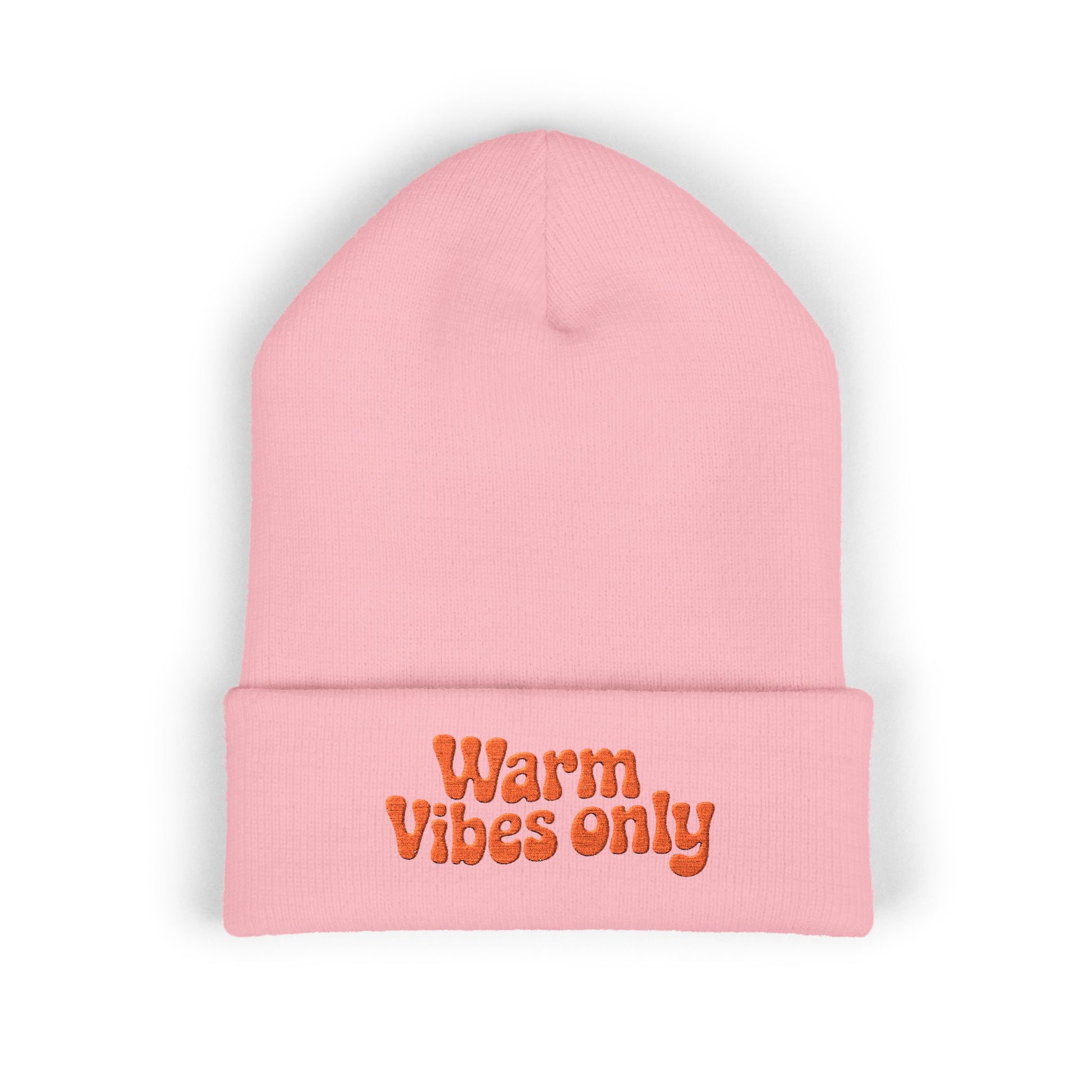 Pink beanie with 'Warm Vibes only' text on a white background. Close-up of cheerful orange “Warm vibes only” embroidery on winter knit hat.