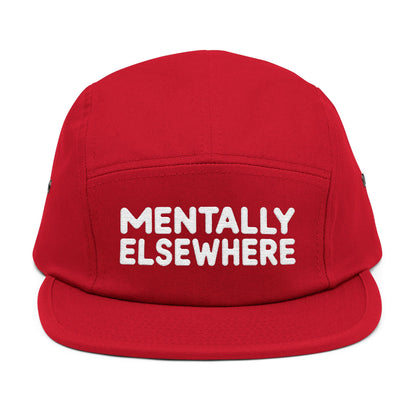 Red cap with 'MENTALLY ELSEWHERE' text on a white background. Mentally Elsewhere embroidered text design on five-panel cap. TEEZOCA