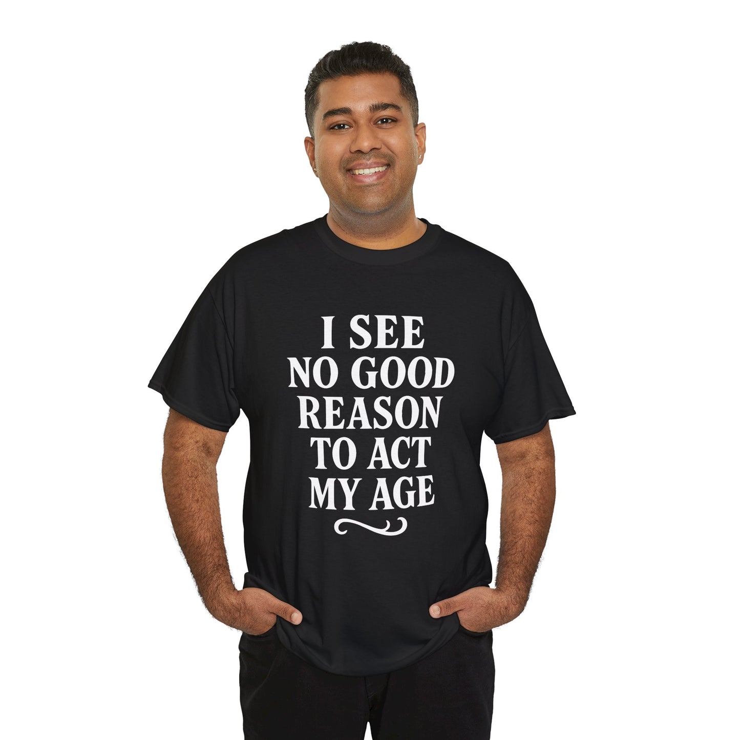 “Man wearing black ‘I See No Good Reason To Act My Age’ funny text t‑shirt, front view.”

