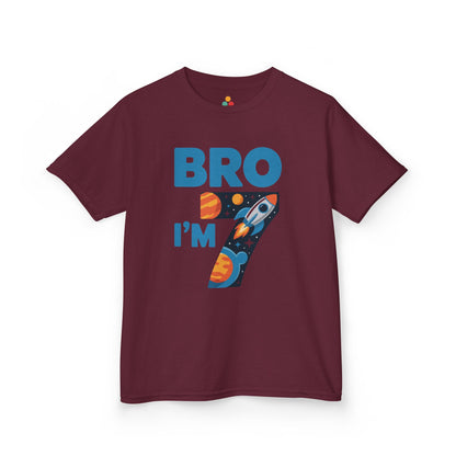 “Maroon ‘Bro I’m 7’ space rocket birthday shirt, bold blue lettering and number 7 full of planets and stars, flat lay.”

