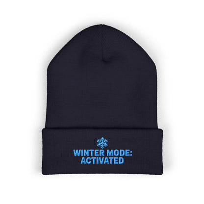 Black beanie with blue text 'Winter Mode: Activated' on a white background. Cuffed winter hat with light-blue snowflake and seasonal slogan