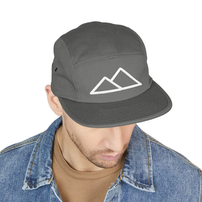 Gray cap with mountain logo worn by a person on a white background. Minimal mountain outline design embroidered on a 5-panel cap. TEEZOCA