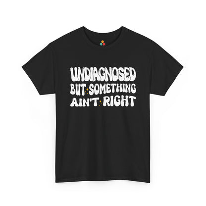 “Teezoca Undiagnosed But Something Ain’t Right shirt, wavy white retro text with small yellow sparkles, black tee, front view.”​


