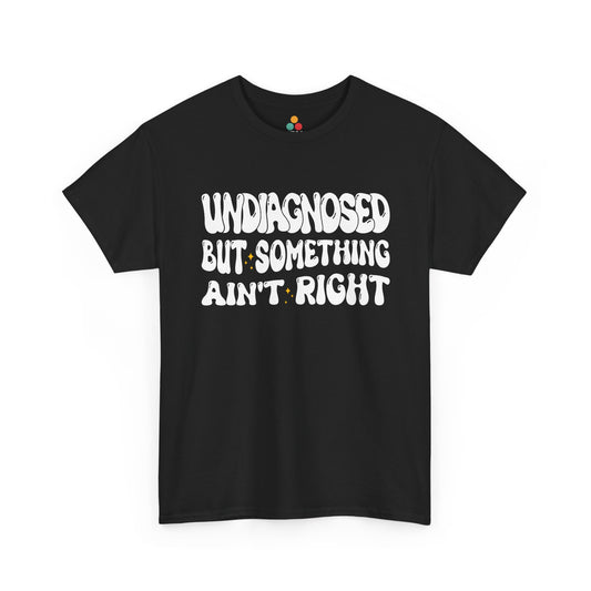 “Teezoca Undiagnosed But Something Ain’t Right shirt, wavy white retro text with small yellow sparkles, black tee, front view.”​


