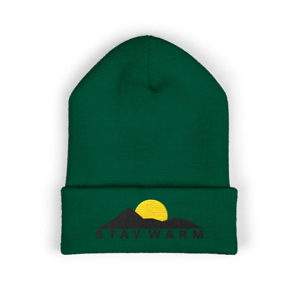 Green beanie with embroidered design and text on a white background