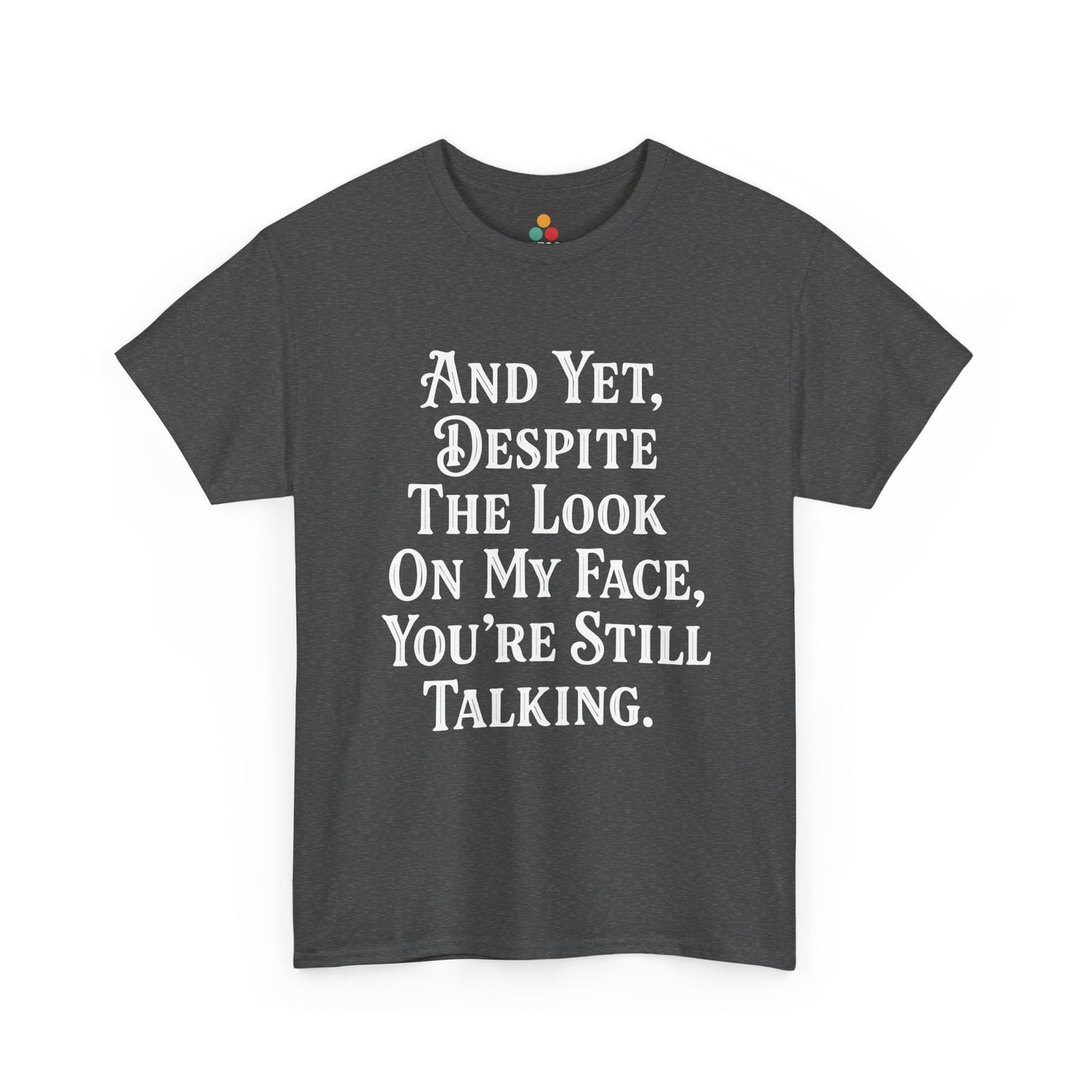 “Teezoca And Yet Despite the Look on My Face You’re Still Talking shirt, snarky white text graphic, charcoal gray tee, front.”

