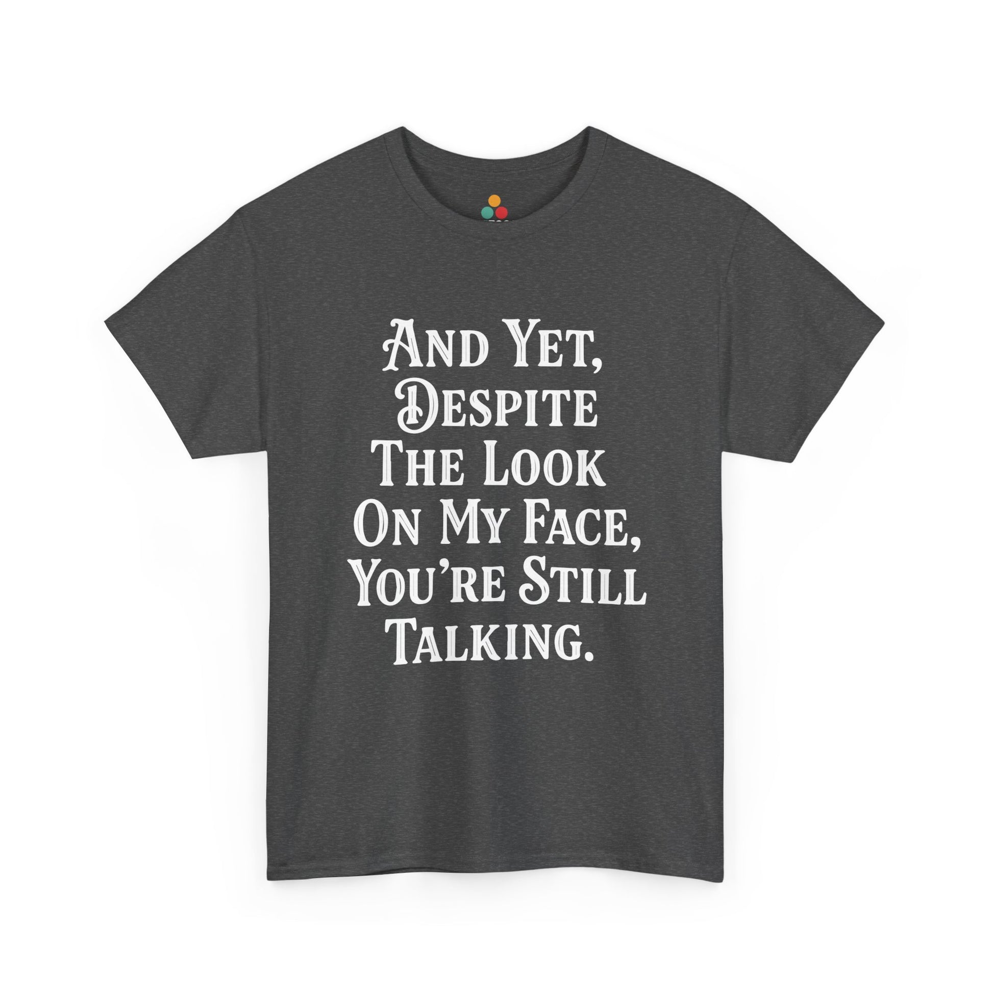 “Teezoca And Yet Despite the Look on My Face You’re Still Talking shirt, snarky white text graphic, charcoal gray tee, front.”

