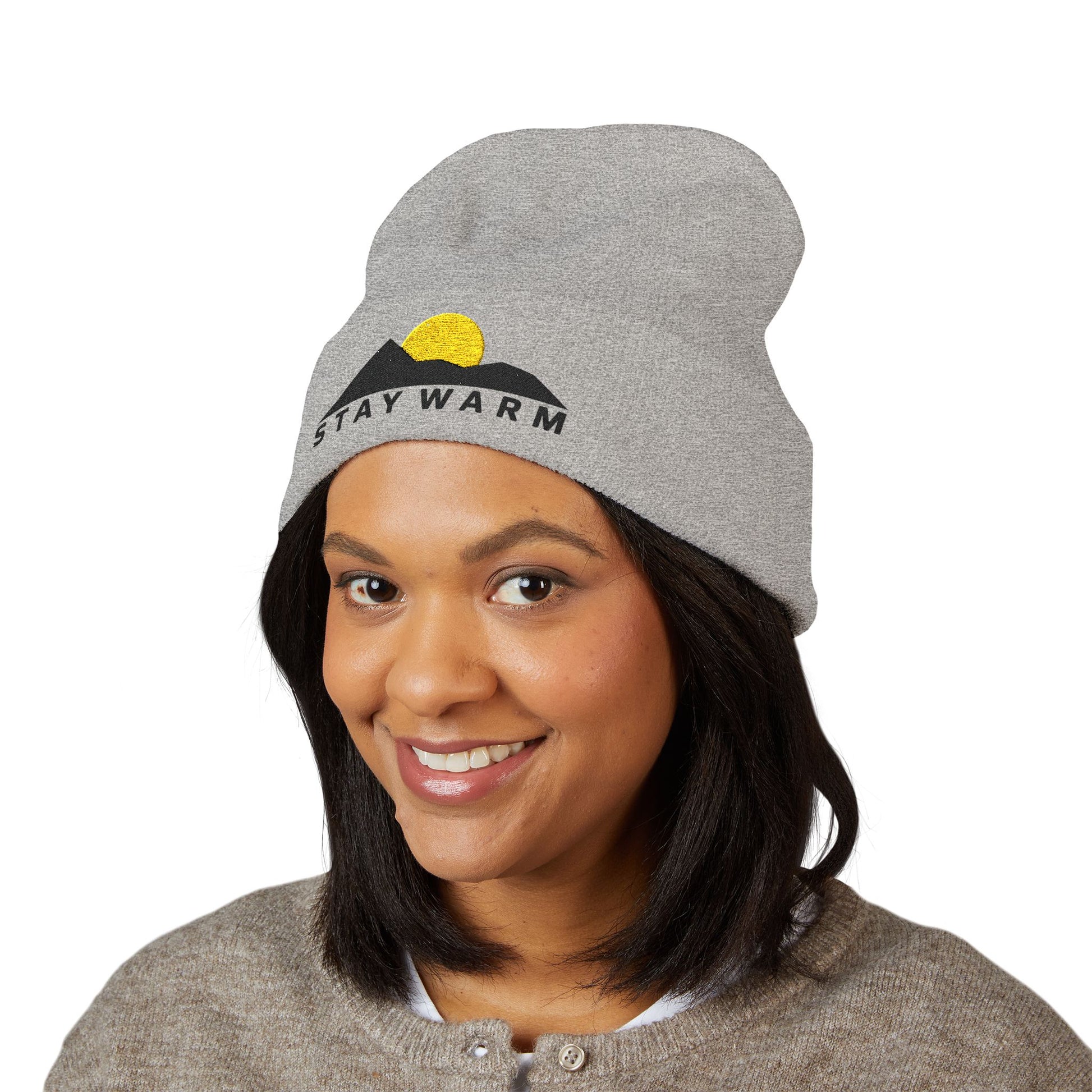 Person wearing a gray beanie with 'Stay Warm' text and mountain graphic on a white background