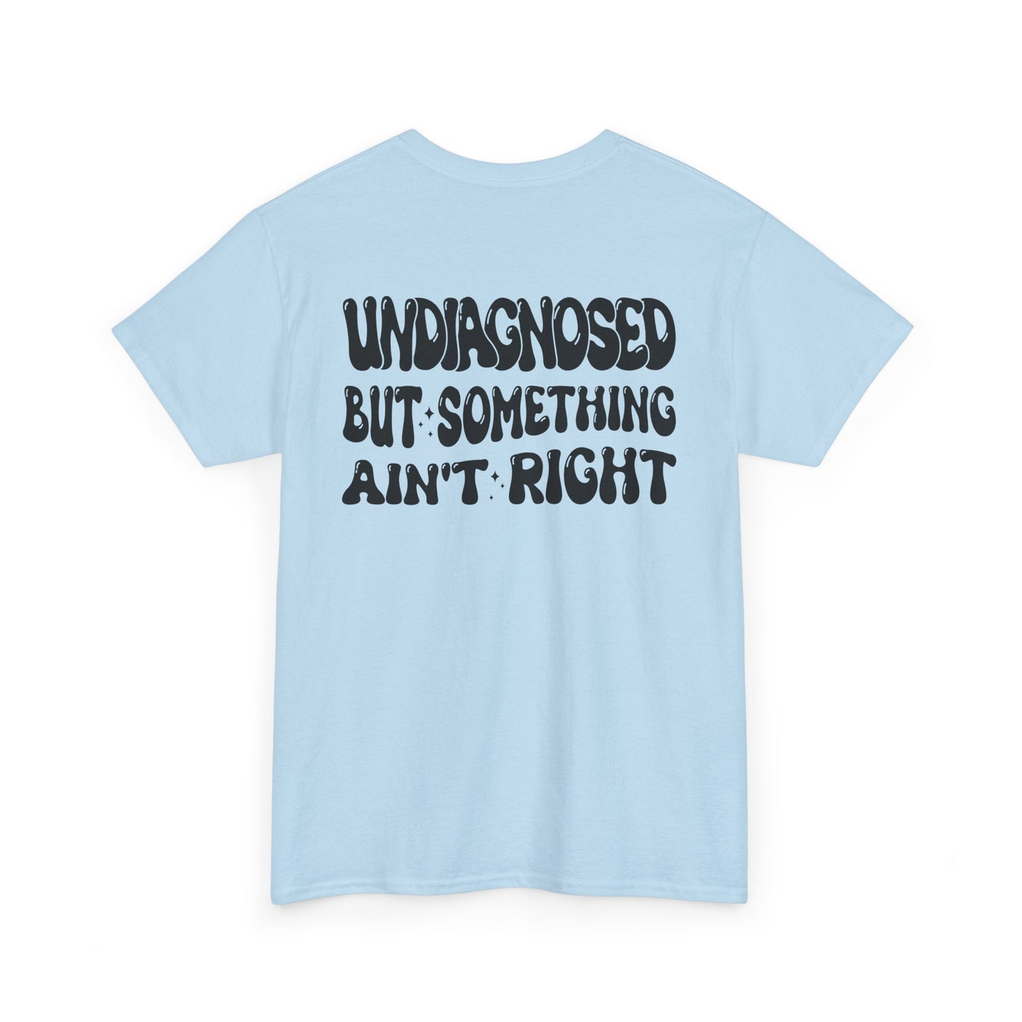 Back Print of a Light Blue T-shirt featuring the viral meme phrase "Undiagnosed But Something Ain't Right" in bold wavy retro typography, a trending funny mental health meme shirt, unhinged humor tee, therapy meme graphic, and relatable back print statement design.
