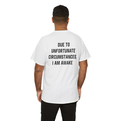 Back Print of a Light Pink T-shirt featuring bold black text reading "Due To Unfortunate Circumstances, I Am Awake," funny back print sarcastic quote shirt, not a morning person tee, dry humor graphic shirt, and blunt statement design.

