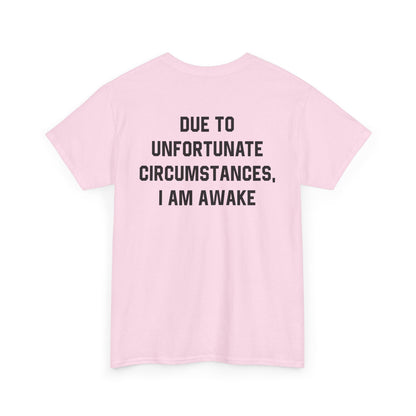 Back Print of a Light Pink T-shirt featuring bold black text reading "Due To Unfortunate Circumstances, I Am Awake," funny back print sarcastic quote shirt, not a morning person tee, dry humor graphic shirt, and blunt statement design.
