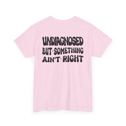 Back Print of a Light Pink T-shirt featuring the viral meme phrase "Undiagnosed But Something Ain't Right" in bold wavy retro typography, a trending funny mental health meme shirt, unhinged humor tee, therapy meme graphic, and relatable back print statement design.
