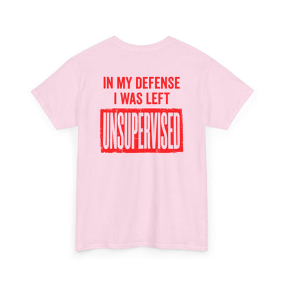 Back Print of a light pink T-shirt featuring the bold red and cream quote “In My Defense I Was Left Unsupervised,” a funny back print statement tee with retro typography, sarcastic quote shirt, witty adult humor graphic, dry humor novelty apparel, bold statement t-shirt, and playful sarcasm design for fans of funny quote shirts.
