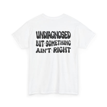 Back Print of a white T-shirt featuring the viral meme phrase "Undiagnosed But Something Ain't Right" in bold wavy retro typography, a trending funny mental health meme shirt, unhinged humor tee, therapy meme graphic, and relatable back print statement design.

