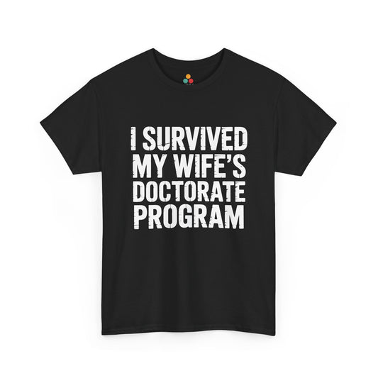 Black TEEZOCA t‑shirt with bold white “I SURVIVED MY WIFE’S DOCTORATE PROGRAM” text shown flat.