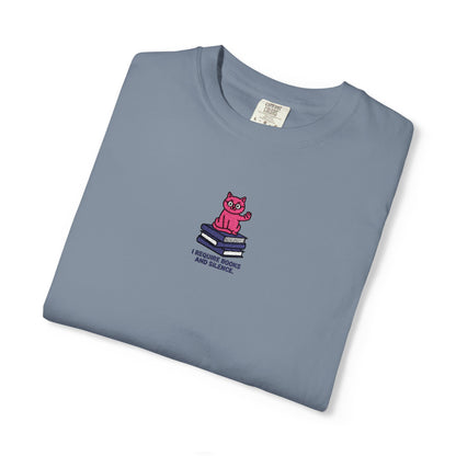 Blue jean Comfort Colors®  shirt featuring an embroidered pink cat sitting on books with the saying “I Require Books and Silence.”
