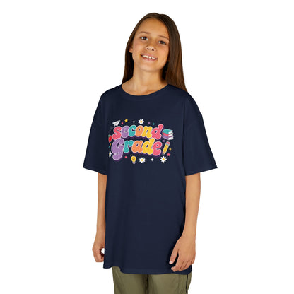 Child wearing a navy t-shirt with 'Second Grade!' printed on it against a white background. TEEZOCA t-shirt with bold Second Grade word art, fitting a second grade kids shirt for the first day of school.