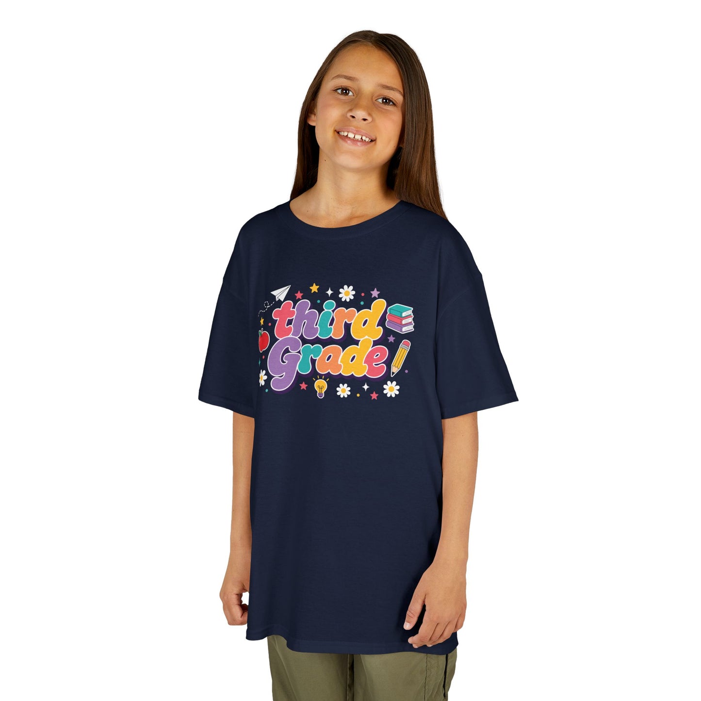 Child wearing a navy t-shirt with 'third grade!' printed on it against a white background. TEEZOCA t-shirt with rainbow school lettering for parents browsing a 3rd Grade Shirt for Girls.