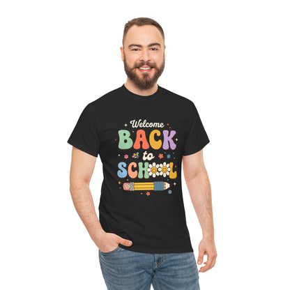 Close-up of Black T-shirt featuring a colorful retro "Welcome Back to School" graphic with groovy lettering, smiling pencils, flowers, and pastel rainbow colors.

