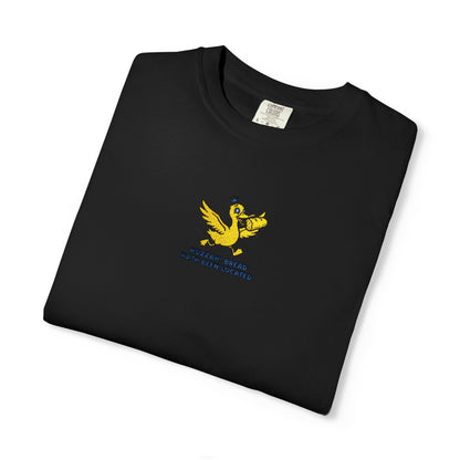 Close-up of a Comfort Colors®   Black shirt featuring an embroidered yellow duck carrying bread with the saying “Huzzah! Bread Must Be Located.”

