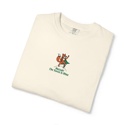 Close-up of a Comfort Colors® Ivory shirt featuring an embroidered orange fox in a green cape with the saying "Huzzah! The Forest Is Mine."


