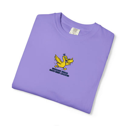 Close-up of a Comfort Colors®   Violet shirt featuring an embroidered yellow duck carrying bread with the saying “Huzzah! Bread Must Be Located.”


