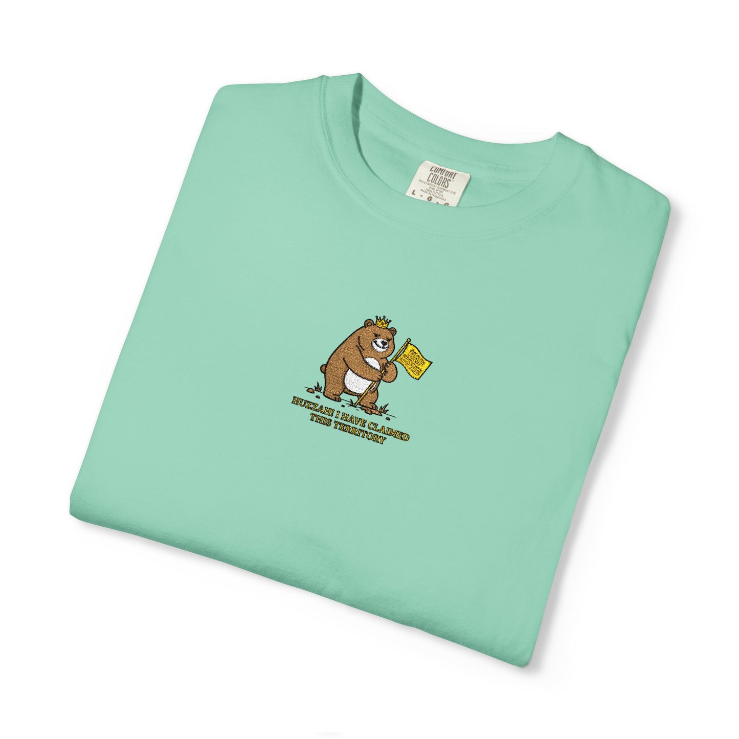  Close-up of a Comfort Colors® mint green shirt featuring an embroidered grumpy bear holding a "Do Not Enter" flag with the saying "Huzzah! I Have Claimed This Territory.

