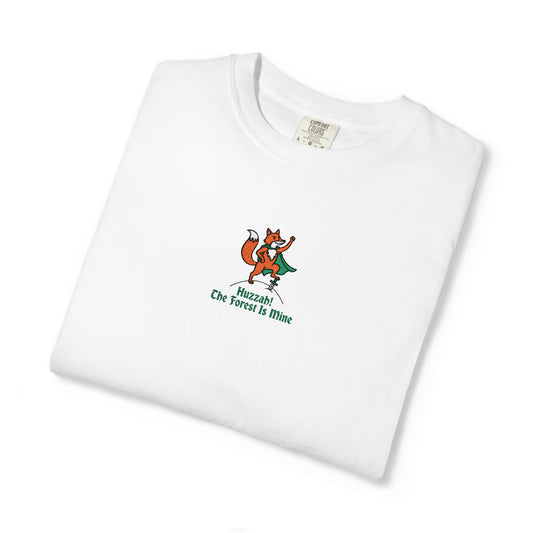 Close-up of a Comfort Colors® shirt featuring an embroidered orange fox in a green cape with the saying "Huzzah! The Forest Is Mine."

